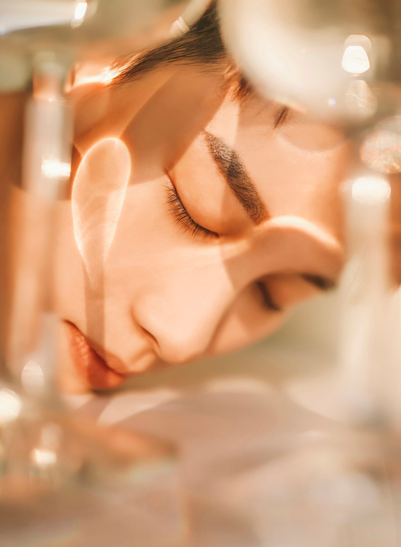 Woman portrait with closed eyes through glass