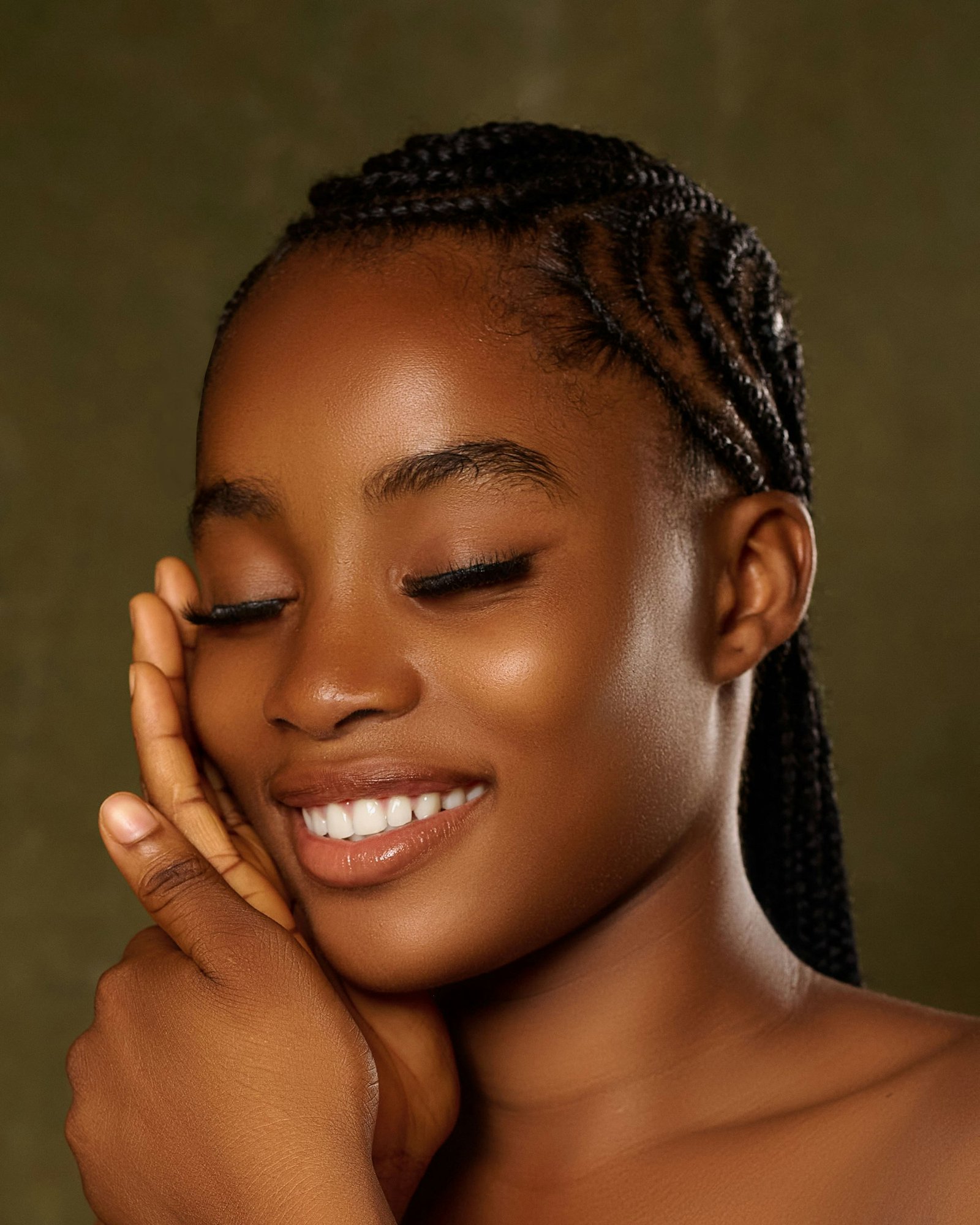 Smiling young woman with braided hair and closed eyes