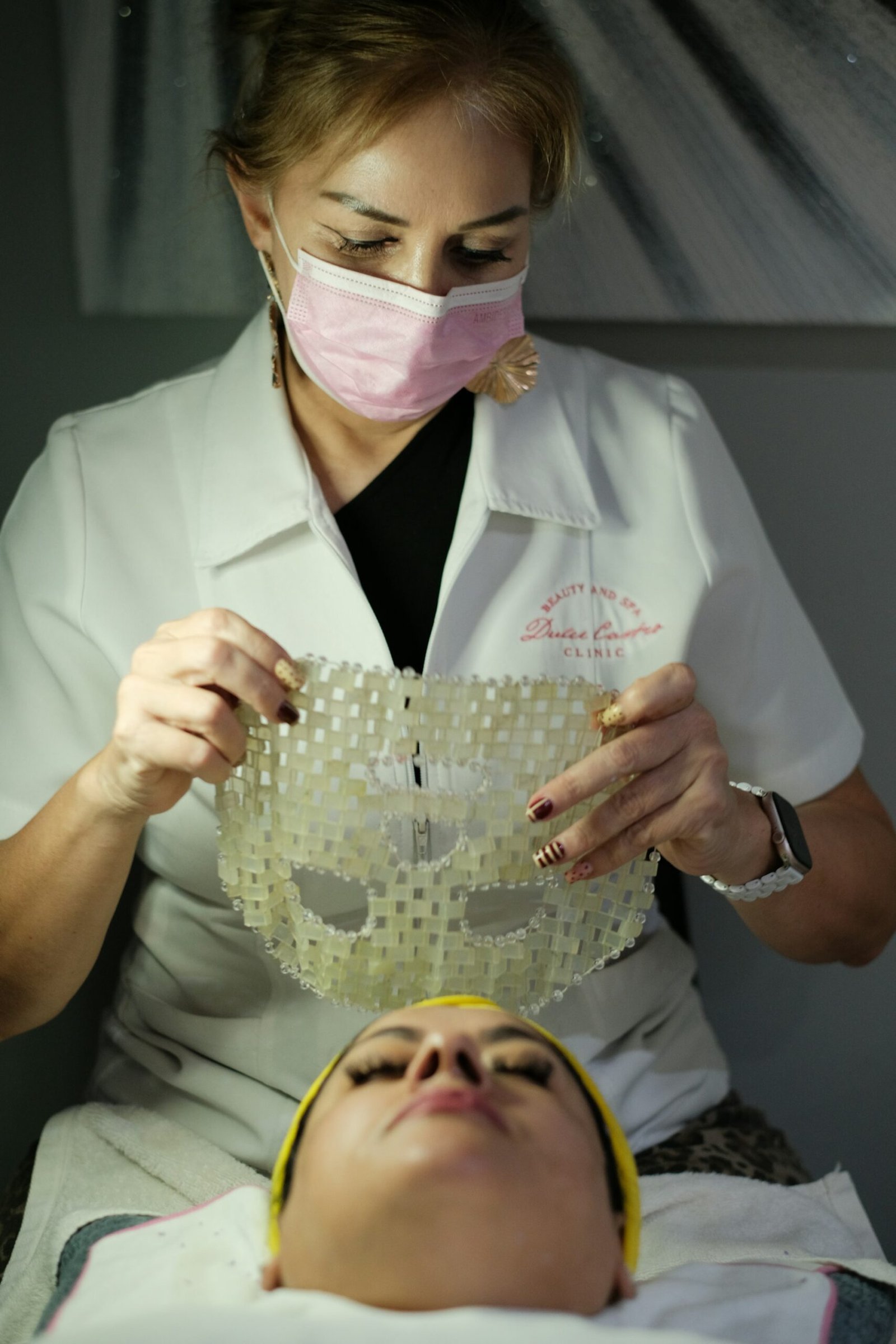 Woman applies a clear textured mask to another woman's face