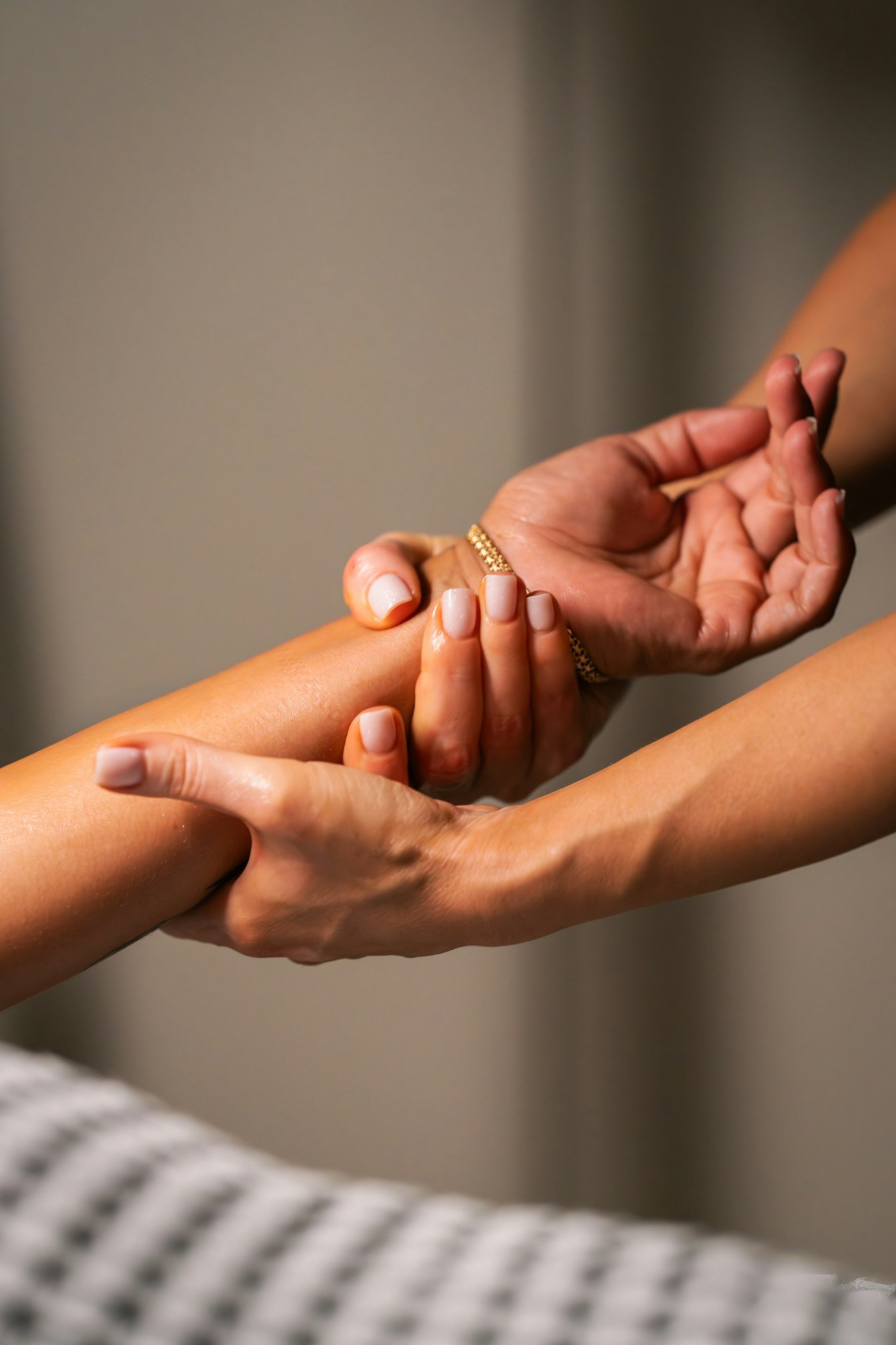 Hands massaging a forearm with gentle pressure