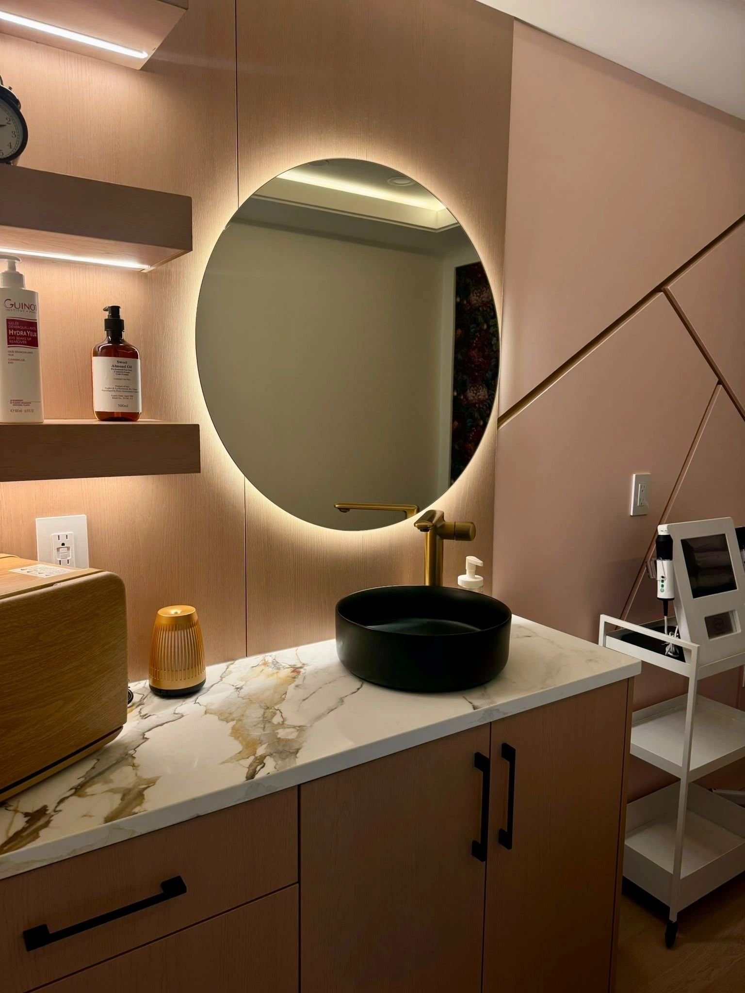 Marble vanity with a black basin and round mirror